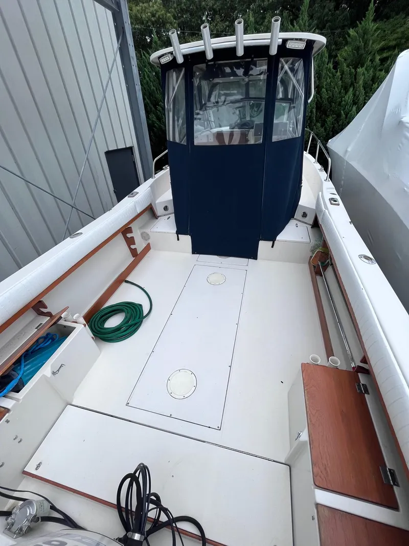 Slide: The Image of 1987 Grady-White 24 Offshore boat with spacious deck and blue canopy. - 8