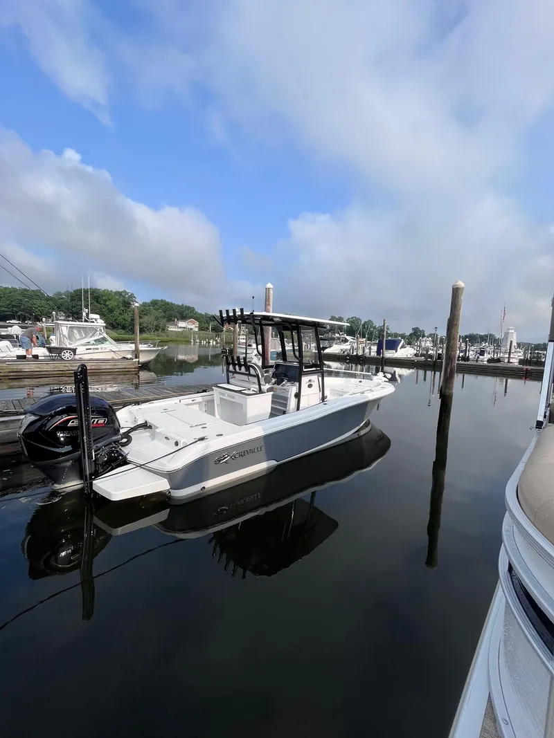 Slide: The Image of 2023 Crevalle 24 HCO boat docked in a serene marina setting. - 14