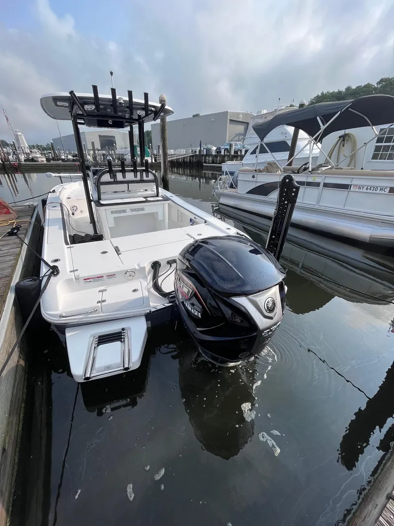 Slide: The Image of 2023 Crevalle 24 HCO boat docked with outboard motor in marina. - 2