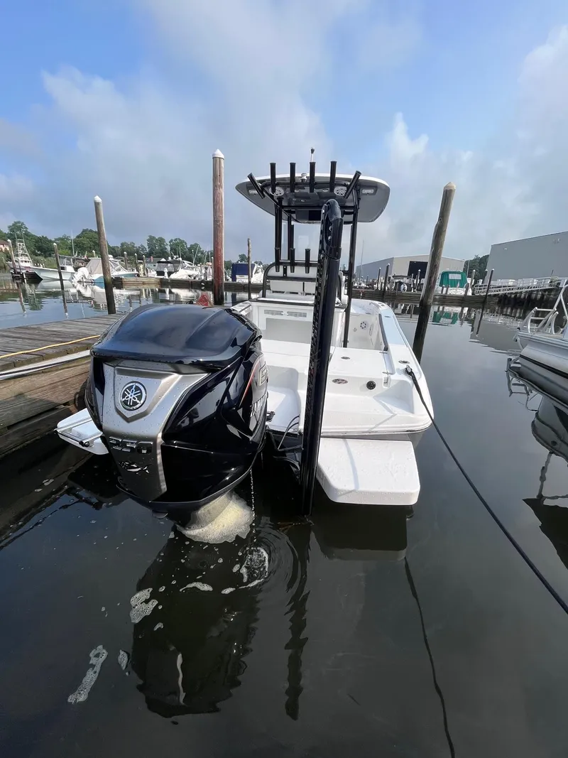 Slide: The Image of 2023 Crevalle 24 HCO boat docked, featuring a powerful outboard motor. - 5
