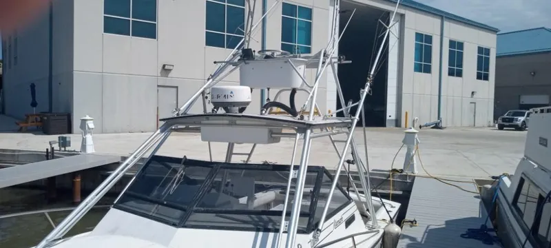 Slide: The Image of 1994 Albemarle 27sf boat docked at a marina with industrial buildings in the background. - 5