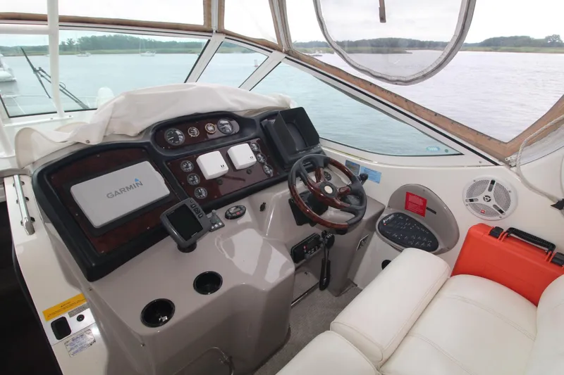 Slide: The Image of 2004 Cruisers Yachts 405 Express Motoryacht helm with Garmin navigation, overlooking serene waters. - 16