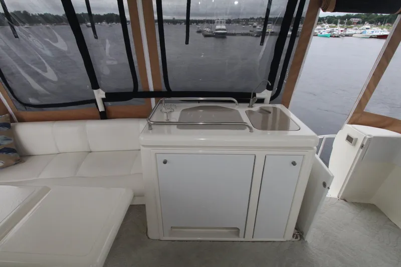 Slide: The Image of 2004 Cruisers Yachts 405 Express Motoryacht interior with sink and seating, overlooking marina. - 20