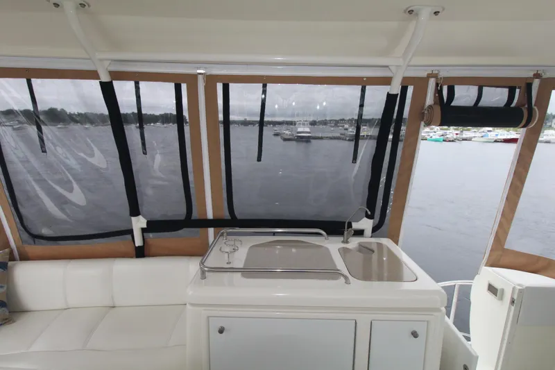 Slide: The Image of 2004 Cruisers Yachts 405 Express Motoryacht interior with sink, seating, and marina view. - 21
