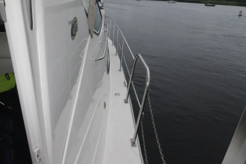 Slide: The Image of 2004 Cruisers Yachts 405 Express Motoryacht deck view with railing over water. - 25
