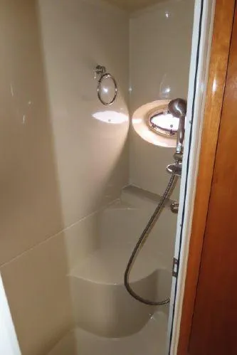 Slide: The Image of 2004 Cruisers Yachts 405 Express Motoryacht bathroom with shower and porthole window. - 26