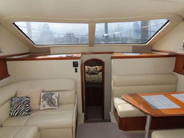 Slide: The Image of Interior of 2004 Cruisers Yachts 405 Express Motoryacht with beige seating and wooden accents. - 28
