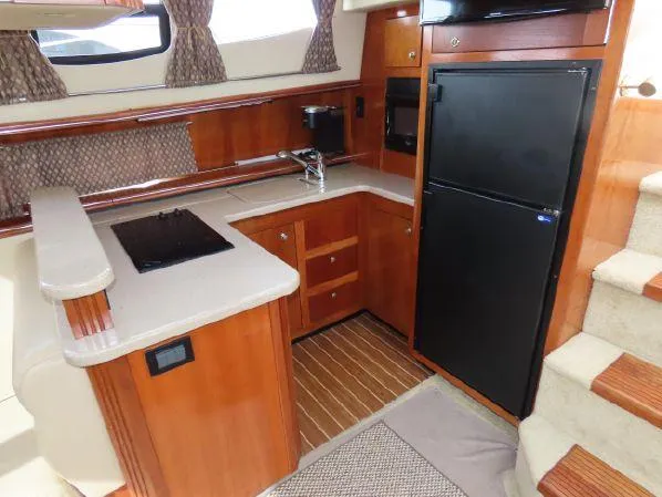 Slide: The Image of 2004 Cruisers Yachts 405 Express Motoryacht kitchen with wood cabinetry and modern appliances. - 30