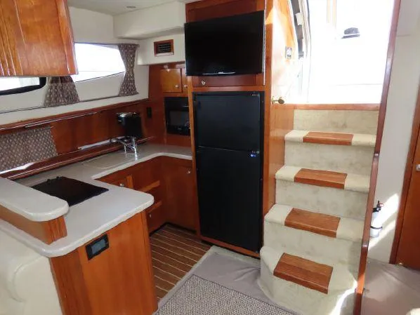 Slide: The Image of Luxurious 2004 Cruisers Yachts 405 Express Motoryacht interior with kitchen, stairs, and modern amenities. - 31