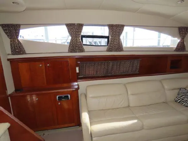 Slide: The Image of Interior of 2004 Cruisers Yachts 405 Express Motoryacht with leather seating and wooden cabinetry. - 33