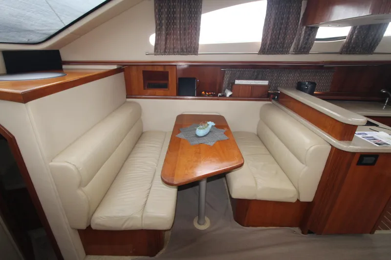 Slide: The Image of 2004 Cruisers Yachts 405 Express Motoryacht interior with dining area and wooden table. - 44