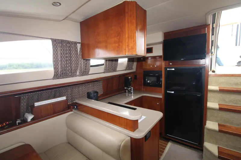 Slide: The Image of 2004 Cruisers Yachts 405 Express Motoryacht interior with kitchen, seating, and stairs. - 47