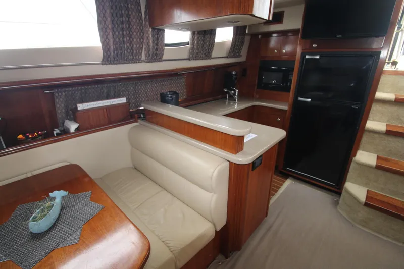 Slide: The Image of 2004 Cruisers Yachts 405 Express Motoryacht interior with kitchen, dining area, and stairs. - 48