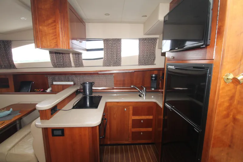Slide: The Image of Interior of 2004 Cruisers Yachts 405 Express Motoryacht kitchen with wood cabinetry and modern appliances. - 49