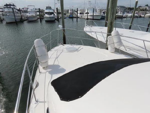 Slide: The Image of 2004 Cruisers Yachts 405 Express Motoryacht docked at marina with other boats. - 5