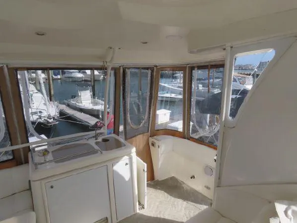 Slide: The Image of 2004 Cruisers Yachts 405 Express Motoryacht interior with marina view through large windows. - 9