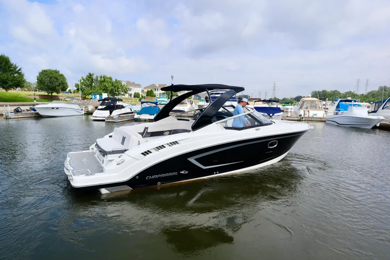 Slide: The Image of 2016 Chaparral 307 SSX boat cruising in a marina, surrounded by other boats. - 13