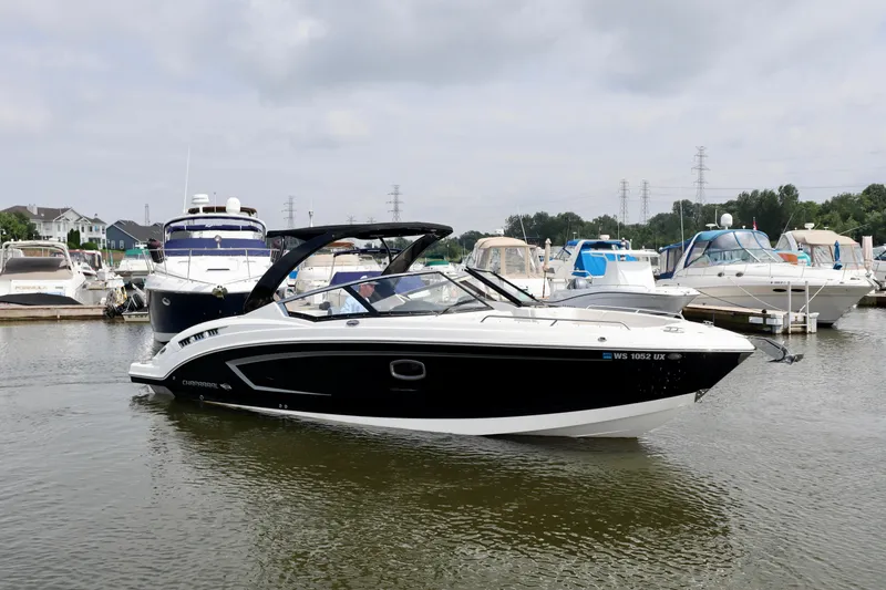 Slide: The Image of 2016 Chaparral 307 SSX boat docked in a marina, surrounded by other vessels. - 16