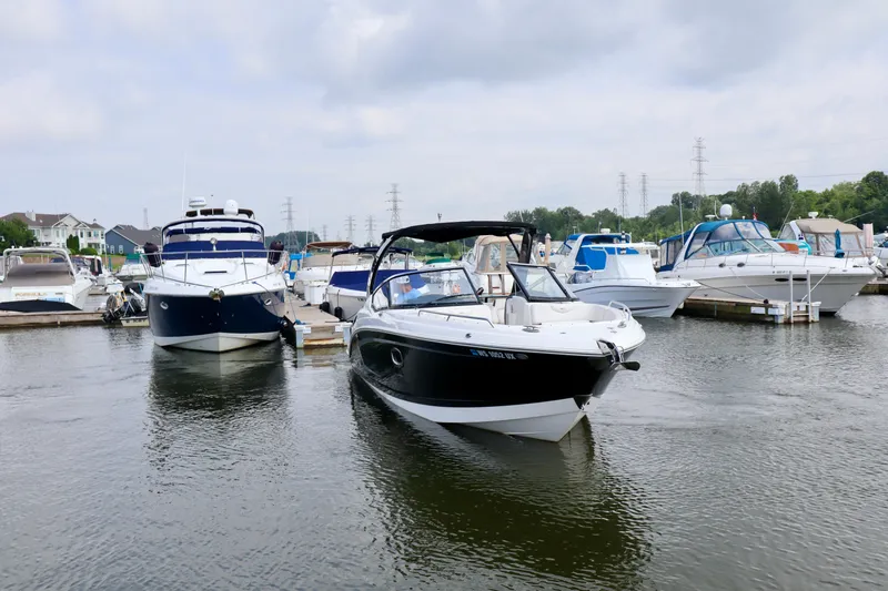 Slide: The Image of 2016 Chaparral 307 SSX boat docked at a marina with other vessels. - 17