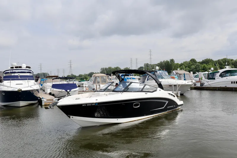 Slide: The Image of 2016 Chaparral 307 SSX boat docked in a marina, surrounded by other vessels. - 19