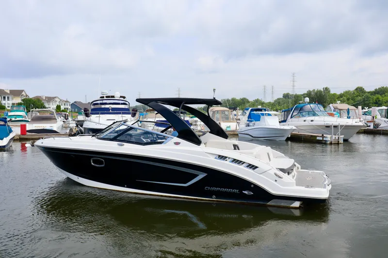 Slide: The Image of 2016 Chaparral 307 SSX boat docked in a marina, surrounded by other boats. - 20
