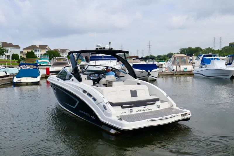 Slide: The Image of 2016 Chaparral 307 SSX boat docked in a marina with other vessels. - 21