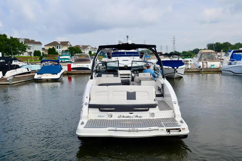 Slide: The Image of 2016 Chaparral 307 SSX boat docked in a marina, surrounded by other boats. - 22