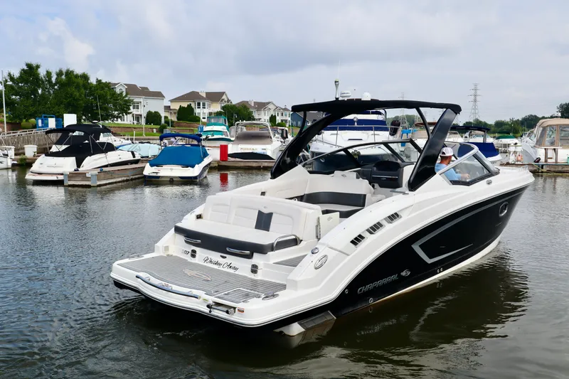 Slide: The Image of 2016 Chaparral 307 SSX boat docked in a marina with other vessels. - 23