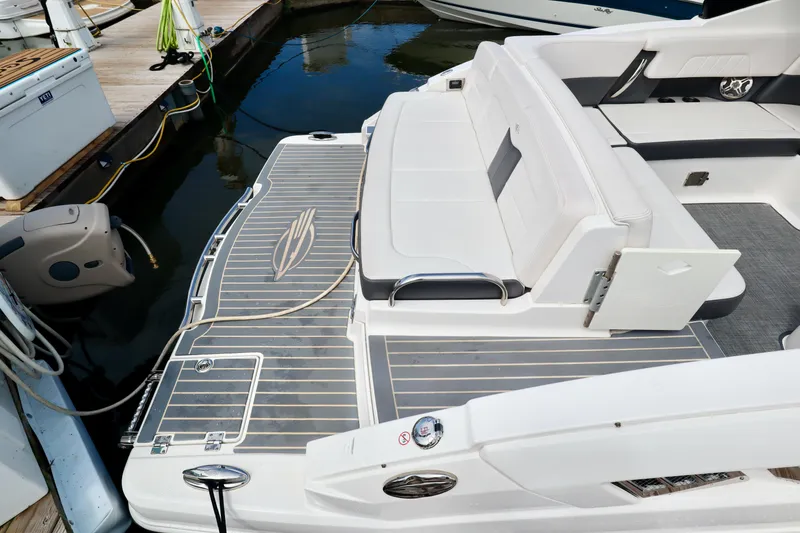 Slide: The Image of 2016 Chaparral 307 SSX boat with sleek seating and swim platform at a marina. - 25