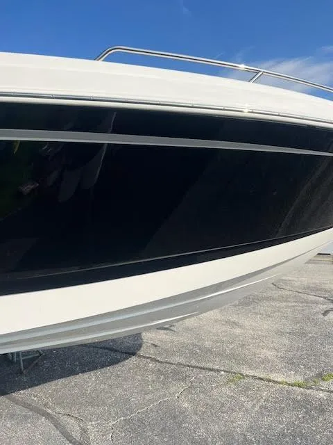 Slide: The Image of 2016 Chaparral 307 SSX boat side view with sleek black and white design. - 40