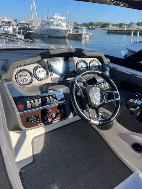 Slide: The Image of 2016 Chaparral 307 SSX boat dashboard with steering wheel and control panel at marina. - 44