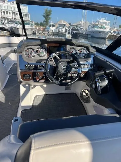 Slide: The Image of 2016 Chaparral 307 SSX boat cockpit with steering wheel and control panel at marina. - 48