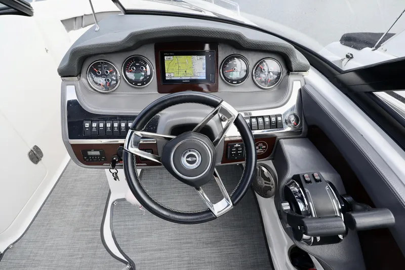 Slide: The Image of 2016 Chaparral 307 SSX boat dashboard with steering wheel, gauges, and navigation system. - 6