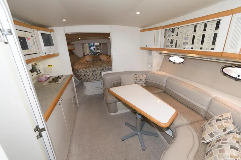 Slide: The Image of 1996 Trojan 350 Express yacht interior with kitchen, dining area, and cozy sleeping quarters. - 10