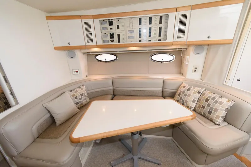 Slide: The Image of 1996 Trojan 350 Express yacht interior with beige seating, table, and control panel. - 11