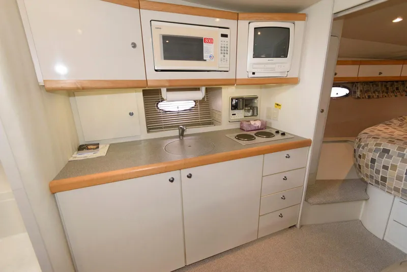 Slide: The Image of Compact kitchen in a 1996 Trojan 350 Express boat with microwave and stove. - 12