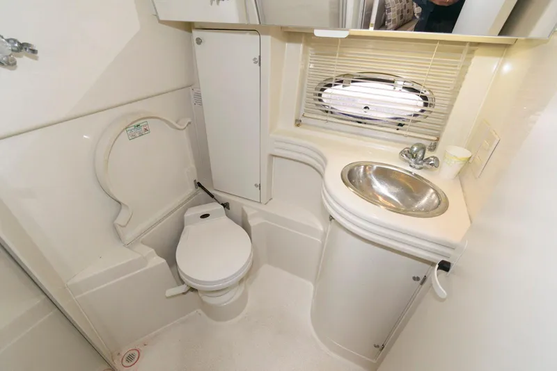 Slide: The Image of Bathroom interior of a 1996 Trojan 350 Express yacht, featuring a toilet and sink. - 15