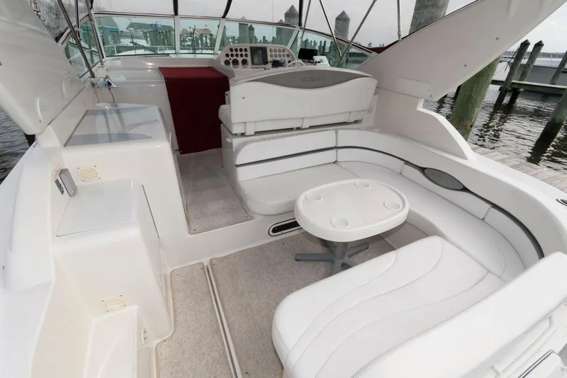 Slide: The Image of 1996 Trojan 350 Express boat interior with white seating and small table. - 4
