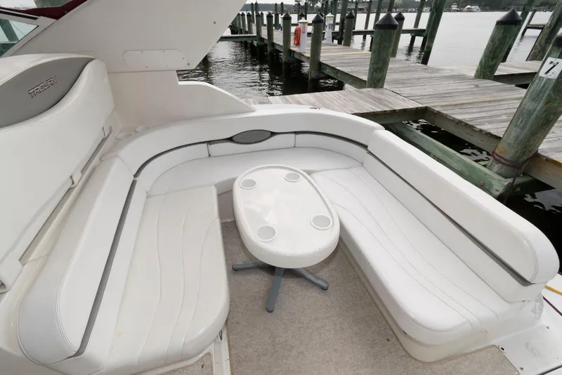 Slide: The Image of 1996 Trojan 350 Express boat interior with white seating and small table by a dock. - 5