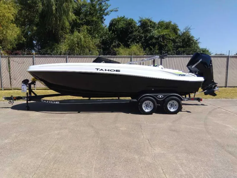 Slide: The Image of 2024 Tahoe T21 boat on trailer, black and white, parked outdoors. - 0