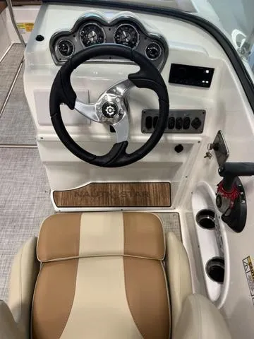Slide: The Image of 2024 NauticStar 203 DC boat dashboard with steering wheel and control panel. - 13