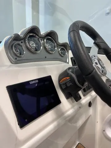 Slide: The Image of 2024 NauticStar 203 DC boat dashboard with steering wheel and gauges. - 15