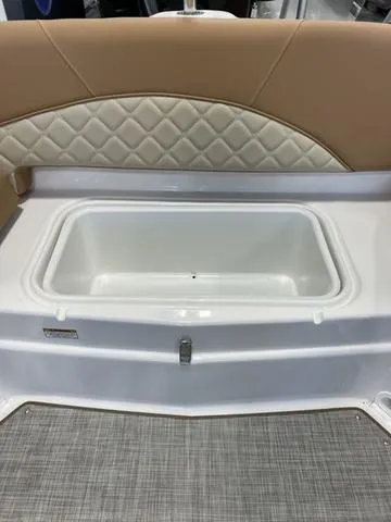 Slide: The Image of 2024 NauticStar 203 DC boat with cushioned seating and built-in storage compartment. - 18