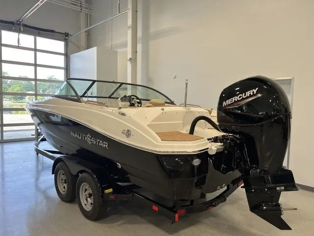 Slide: The Image of 2024 NauticStar 203 DC boat with Mercury outboard motor in showroom. - 5