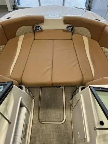 Slide: The Image of 2024 NauticStar 203 DC boat interior with tan cushioned seating and integrated speakers. - 9