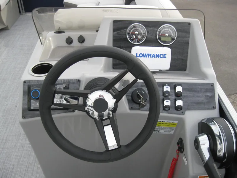 Slide: The Image of 2023 Harris FloteBote Cruiser 230 dashboard with steering wheel and Lowrance display. - 13