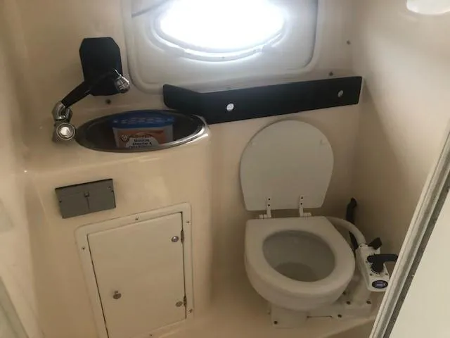Slide: The Image of Compact bathroom in 2003 Rinker Fiesta Vee 270 boat with toilet and sink. - 11