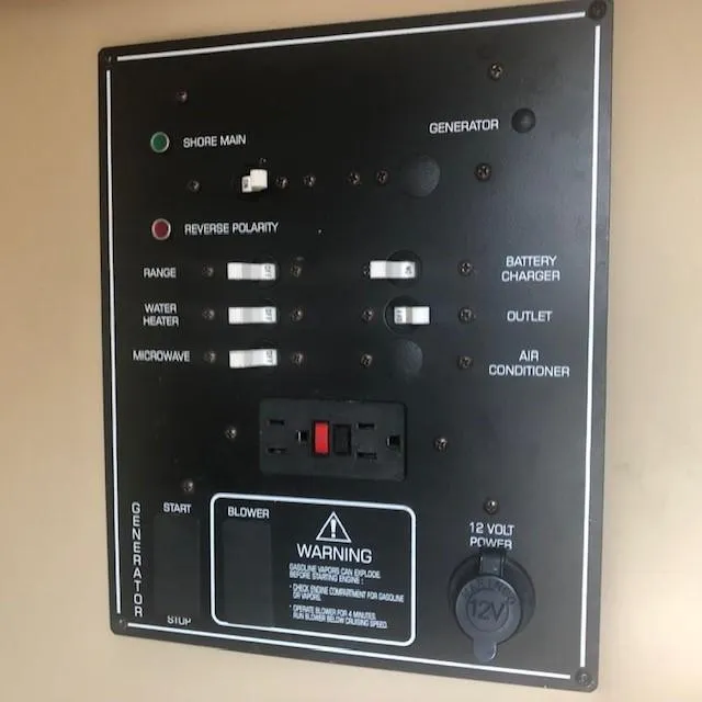 Slide: The Image of 2003 Rinker Fiesta Vee 270 control panel with shore main, generator, and appliance switches. - 13