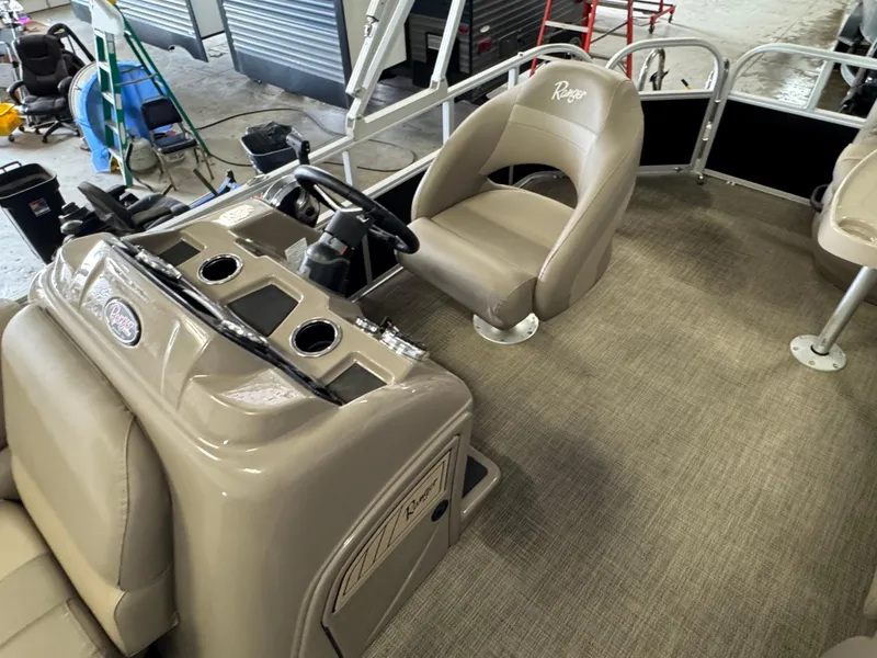 Slide: The Image of 2021 Ranger 200C boat interior with beige seating and steering console. - 10