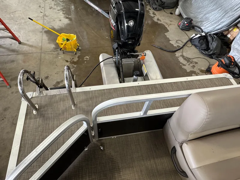 Slide: The Image of 2021 Ranger 200C boat interior with motor, ladder, and seating in a garage setting. - 13